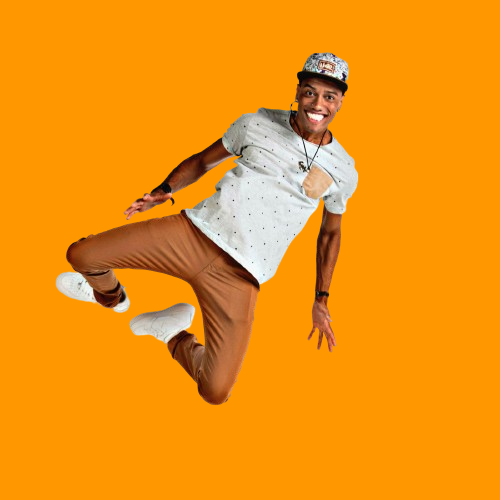 Uma imagem do proprietário do portfólio usando um boné camisa com bolsinho do lado esquerdo, calça begé e tênis branco, ele está fazendo uma sarrada no ar está sorrindo